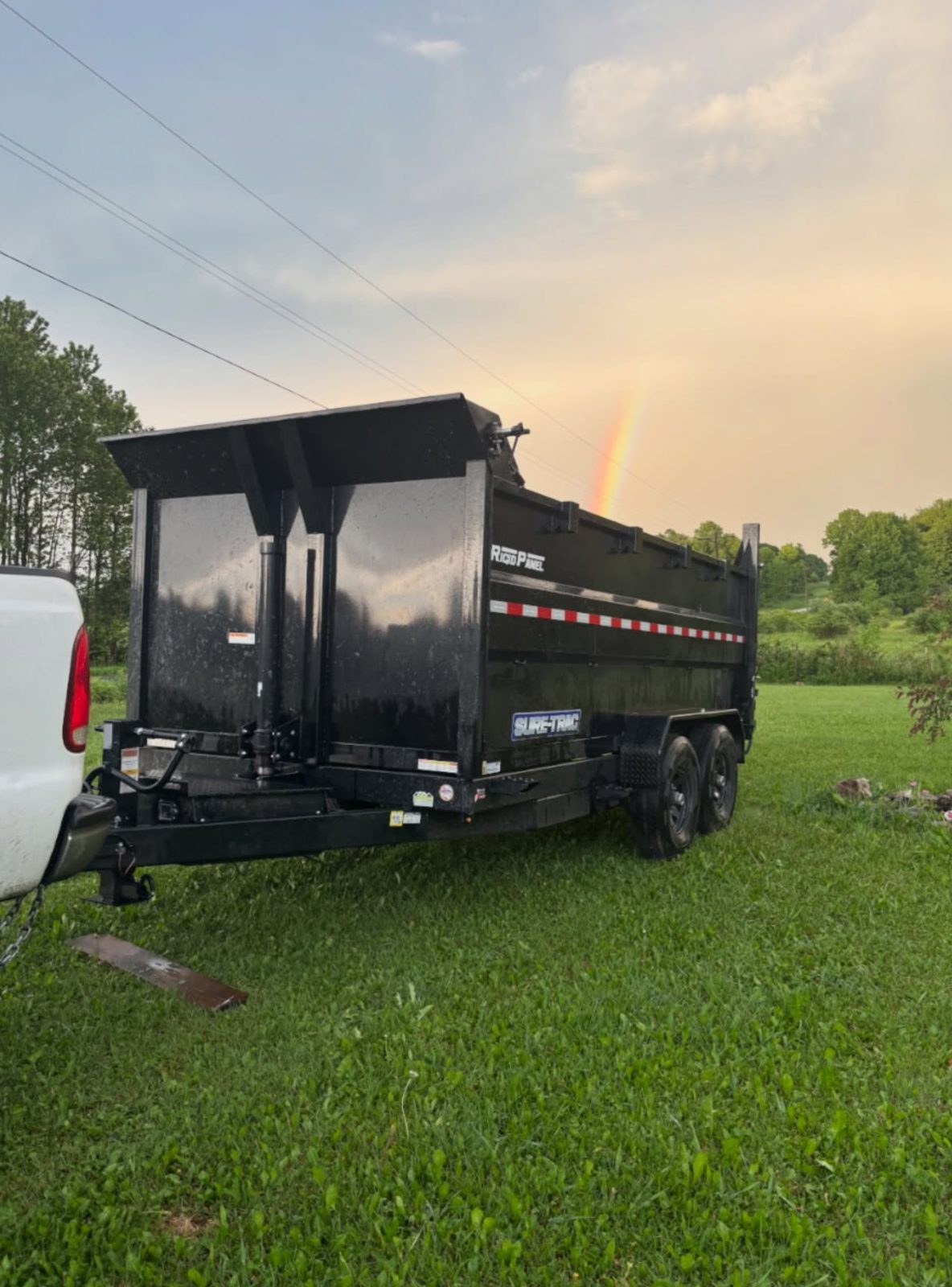 Clean, empty dump trailer ready for the next job with a rainbow in the sky