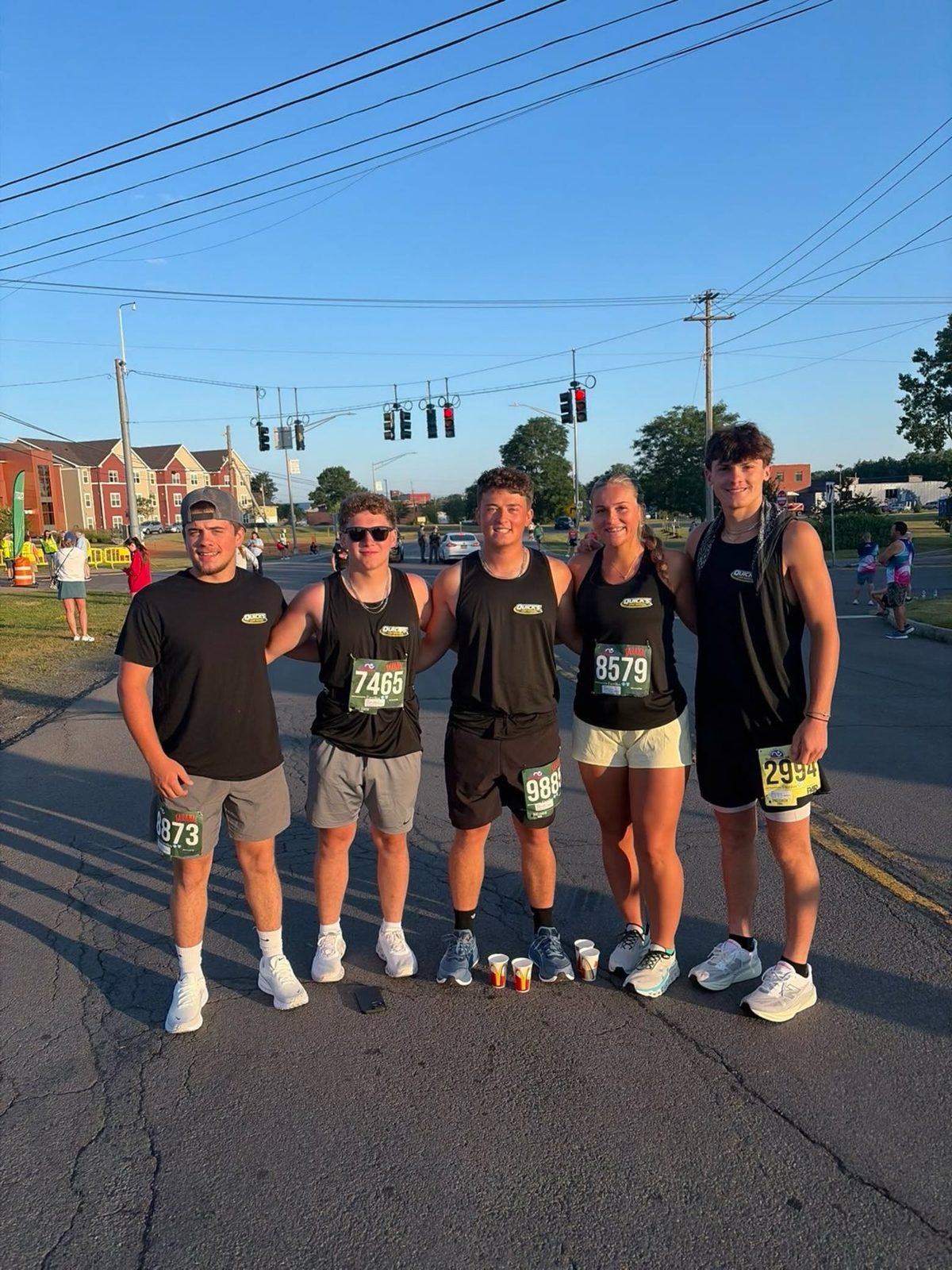 The Quick's Junk Removal crew posing together in matching team shirts